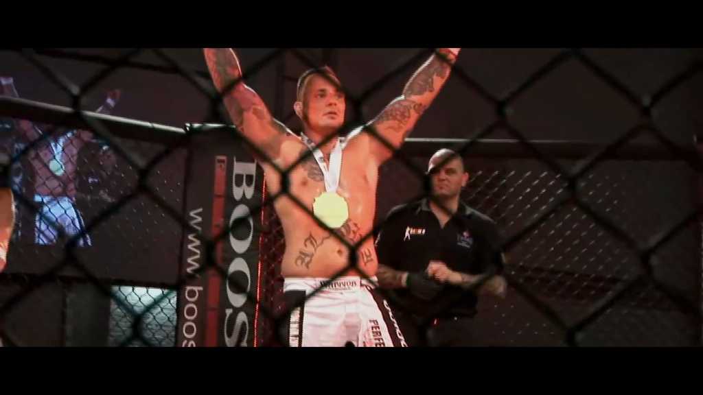 Franky heft zijn armen in overwinning na een MMA-gevecht